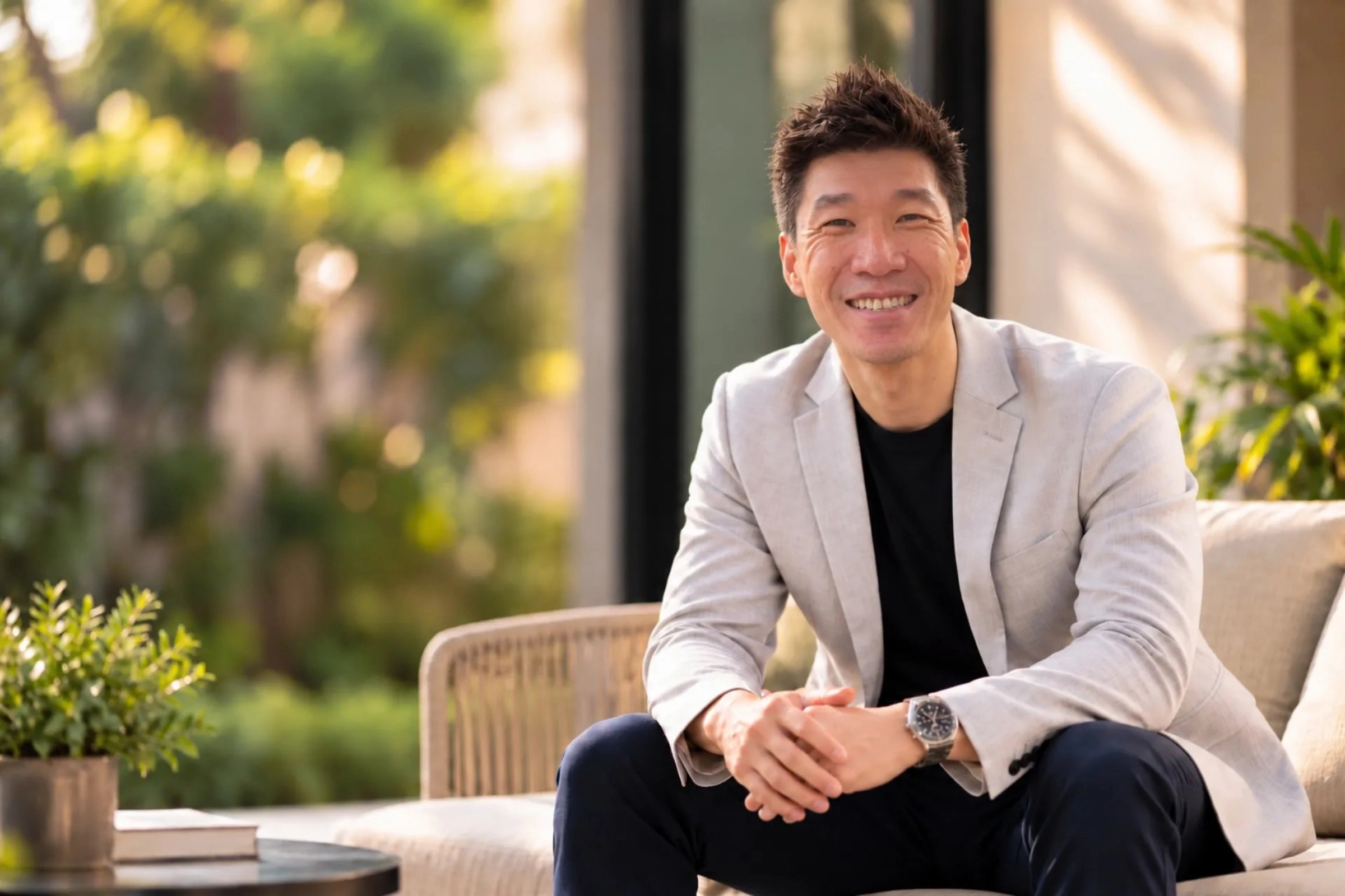 Clarry Au seated in a relaxed outdoor setting
